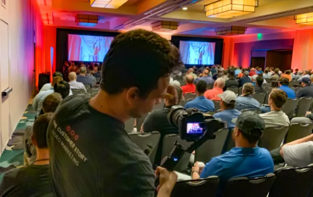 The Customer Story camera operator filming a conference presentation